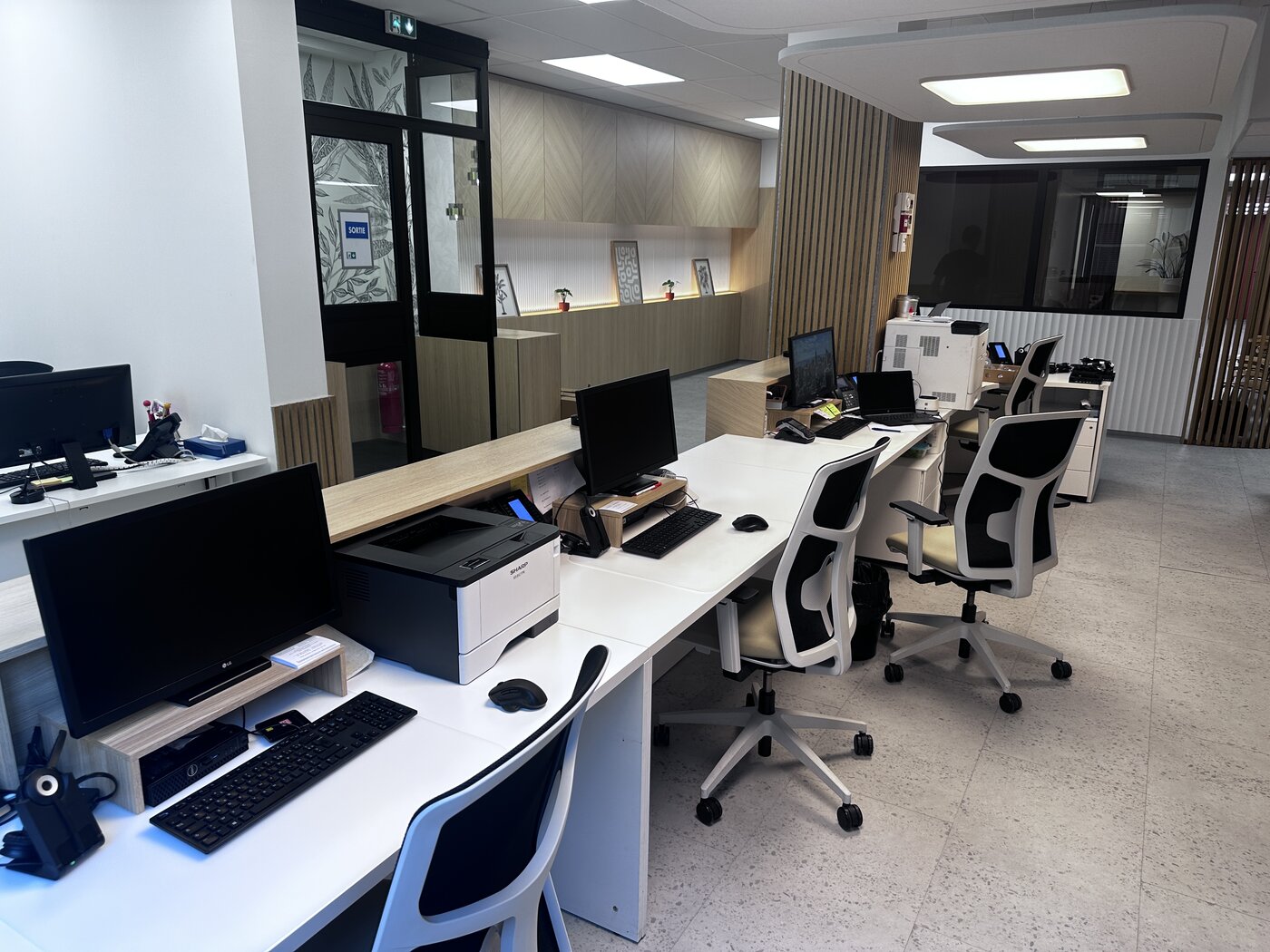 Open space du secrétariat du cabinet d'ophtalmologie d'Antibes avec plusieurs postes informatiques neufs et une imprimante réseau